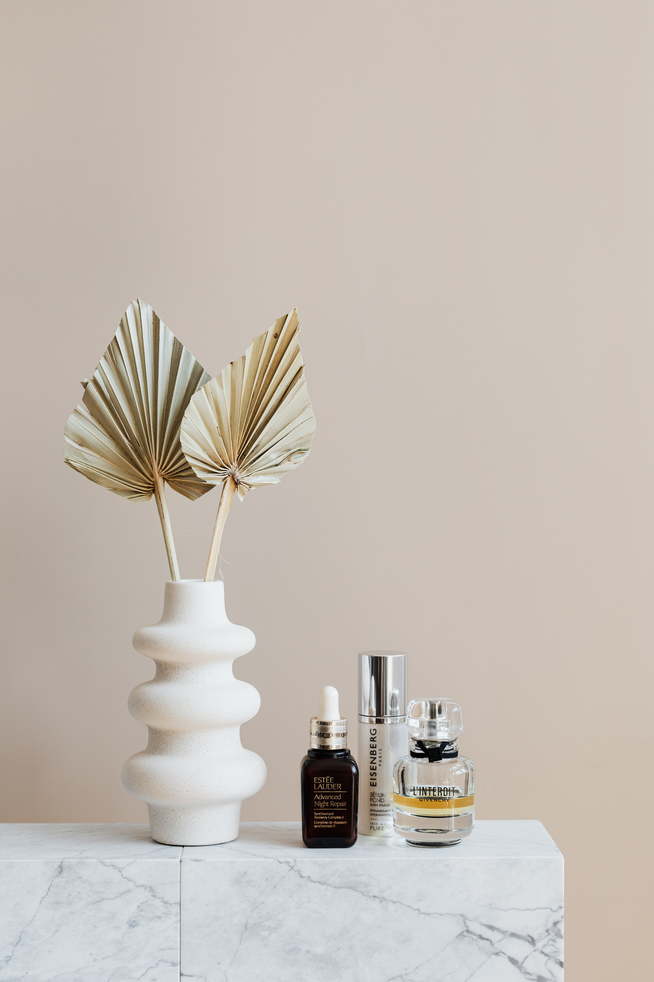 Set of beauty products with artificial branches in vase